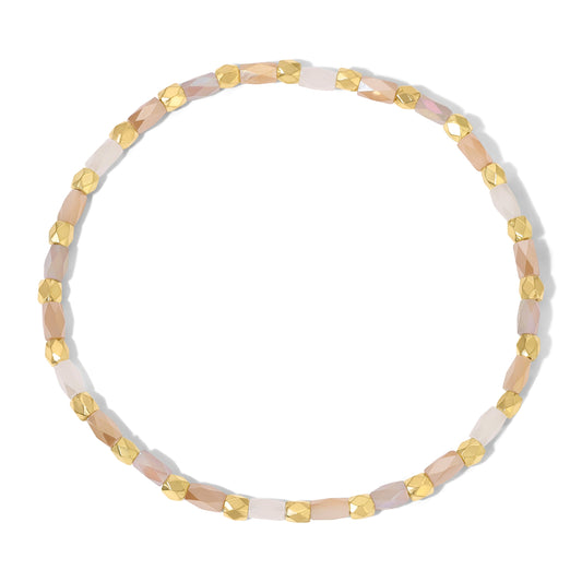 gold and pink beaded bracelet on white background