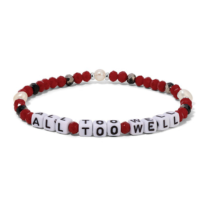 Bracelet with red, white, and black beads spelling 'ALL TOO WELL' on a white background