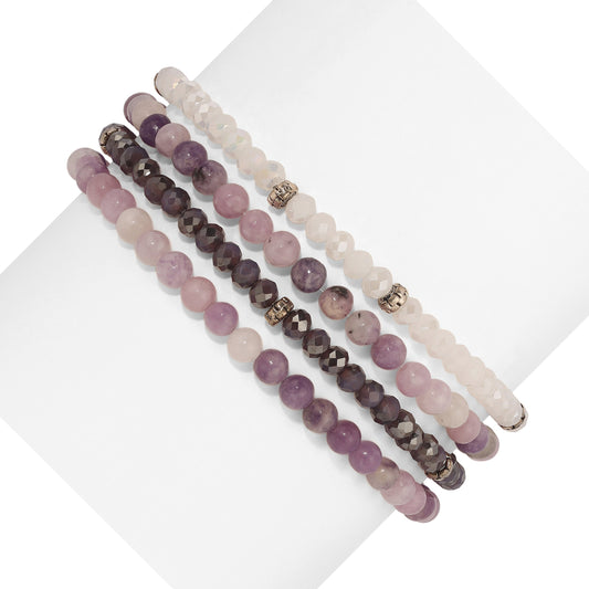 five beaded bracelets in varying shades of purple and white